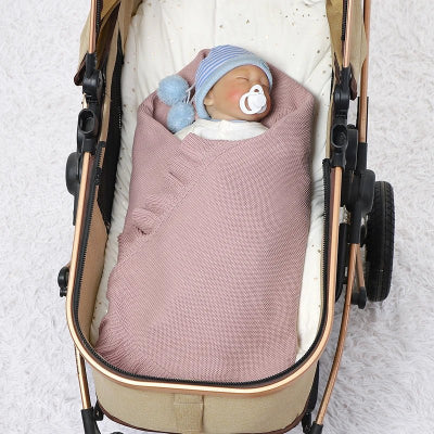 Bébé avec couverture en coton dans la poussette