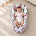 Bébé dans le nid gris à motifs fleuris, vue de trois quarts