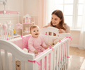 Contour de Lit Bébé souriant assis dans son lit avec maman