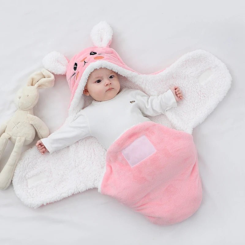 bebe dans une couverture d'emmaillotage rose