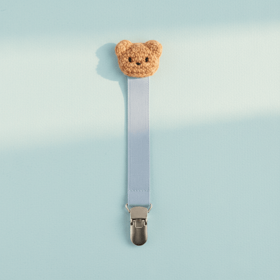 attache tétine coloris bleu Clip ourson bleu poudré fond bleu pastel