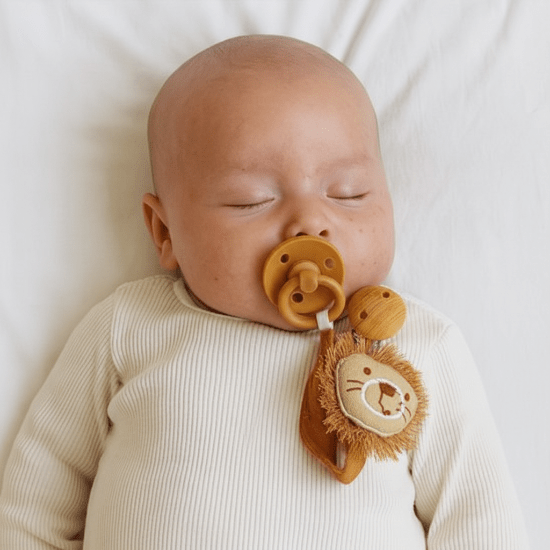 attache sucette pour bebe en Gros plan visage bébé endormi attache lion doré