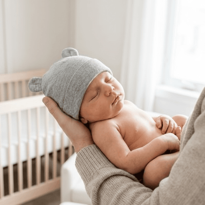 Mains parent bébé endormi bonnet gris ourson