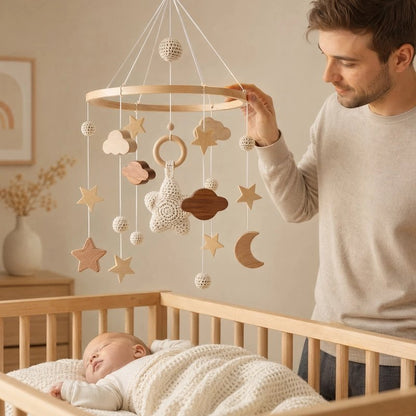 mobile pour lit Bébé jeune homme qui touche le moble avec sa main 